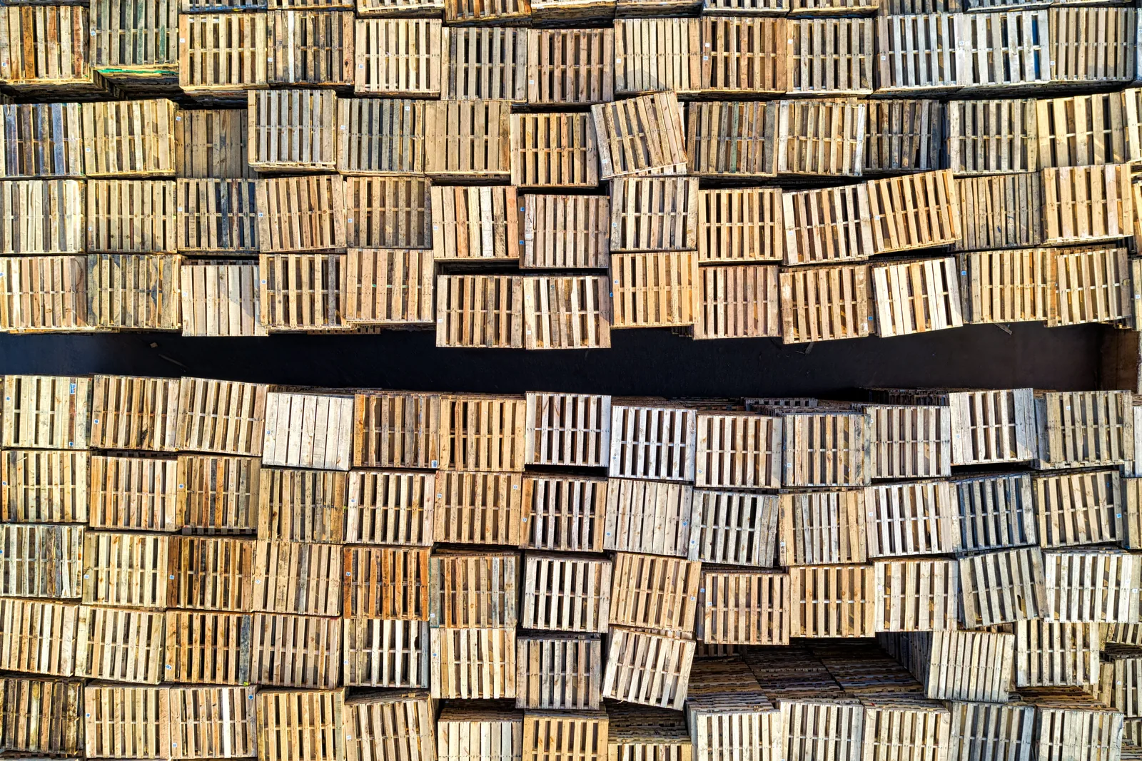 Geordende stapels houten pallets, van bovenaf gezien.